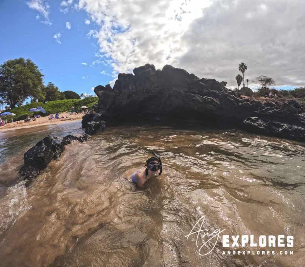 Swimming in front of lava rock cave at Kamaole Beach Park III in Maui Hawaii