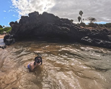 Swimming in front of lava rock cave at Kamaole Beach Park III in Maui Hawaii