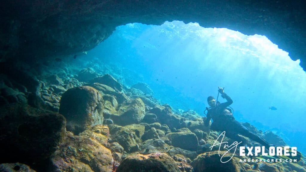 Scuba diver exiting underwater lava tube at Makena Landing in Maui