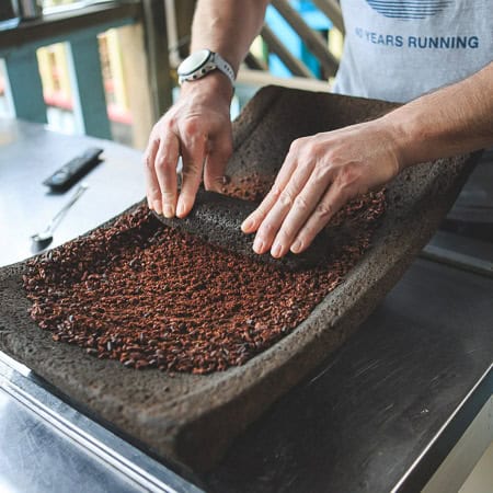 grinding cacao nibs into chocolate
